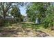 Shaded backyard featuring a grass lawn, fencing, shed and tropical landscaping at 317 19Th S Ave, St Petersburg, FL 33705