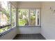 A view from the porch shows a wood floor and window views of mature trees at 317 19Th S Ave, St Petersburg, FL 33705