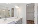 Elegant bathroom featuring double sinks, a large mirror, and a glass-enclosed shower at 33306 Castaway Loop, Wesley Chapel, FL 33543