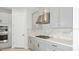 Modern kitchen featuring grey cabinetry, stainless steel appliances, marble backsplash, and a gas cooktop at 33306 Castaway Loop, Wesley Chapel, FL 33543