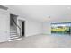 Spacious living area with tile floors, a stairway to the left, and large sliding glass doors with a view at 33306 Castaway Loop, Wesley Chapel, FL 33543