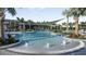 Resort-style pool area with ample lounge seating and lush tropical landscaping with water features at 33306 Castaway Loop, Wesley Chapel, FL 33543
