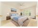 A cozy bedroom features a tufted headboard, ceiling fan, and large sunny windows at 3415 Heards Ferry Dr, Tampa, FL 33618