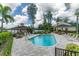 Community pool with lounge chairs, tables, and lush landscaping near the lake at 3415 Heards Ferry Dr, Tampa, FL 33618