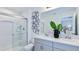 Modern bathroom with double vanity, sleek fixtures, and a glass-enclosed shower with decorative accents at 34234 Polacca Ln, Wesley Chapel, FL 33543