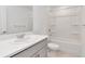 Bright bathroom featuring a single vanity, large mirror, and a shower-tub combo with white tile surround at 34234 Polacca Ln, Wesley Chapel, FL 33543