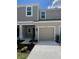 Exterior of two-story townhome features a one-car garage, neutral paint, and well-maintained landscaping at 34234 Polacca Ln, Wesley Chapel, FL 33543