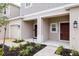 Townhouse exterior showing a covered porch, manicured flower beds and attached garage at 34234 Polacca Ln, Wesley Chapel, FL 33543