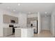 Modern kitchen features stainless steel appliances, a large island, and ample cabinet space at 34234 Polacca Ln, Wesley Chapel, FL 33543