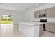 Open-concept kitchen with large island, stainless steel appliances, and sliding glass doors to yard at 34234 Polacca Ln, Wesley Chapel, FL 33543