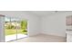 Bright living room featuring tile flooring and sliding glass doors with a view of the landscaped backyard at 34234 Polacca Ln, Wesley Chapel, FL 33543
