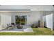 Cozy patio area with a sliding glass door, perfect for outdoor relaxation and entertaining with lush landscaping and privacy fence at 34234 Polacca Ln, Wesley Chapel, FL 33543