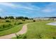 A curved walking path winds through grassy areas near a neighborhood and lake, offering a scenic view at 34234 Polacca Ln, Wesley Chapel, FL 33543