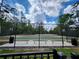 Outdoor basketball court with green surface, benches, fencing, and lighting for evening play at 3901 Silverlake Way, Wesley Chapel, FL 33544