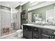 Bathroom with double vanity, step-in shower and green accent wall at 3901 Silverlake Way, Wesley Chapel, FL 33544