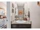 Half bathroom with granite counters, a dark cabinet and decorative mirror at 3901 Silverlake Way, Wesley Chapel, FL 33544