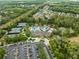 Aerial view of a luxurious community pool area with tennis courts, a clubhouse, and ample parking at 3901 Silverlake Way, Wesley Chapel, FL 33544