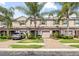 Well-manicured townhouse exterior boasts one car garage, brick paved driveway, and lush landscaping at 3901 Silverlake Way, Wesley Chapel, FL 33544