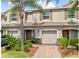 Charming townhouse featuring a one car garage, a front yard with lush green bushes and beautiful landscaping at 3901 Silverlake Way, Wesley Chapel, FL 33544