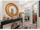 Inviting hallway with wood floors, designer mirror and accent table at 3901 Silverlake Way, Wesley Chapel, FL 33544