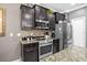 This kitchen features stainless steel appliances, granite countertops and dark cabinetry at 3901 Silverlake Way, Wesley Chapel, FL 33544