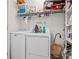 Functional laundry room with modern washer and dryer and storage shelving at 3901 Silverlake Way, Wesley Chapel, FL 33544