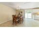Bright dining area features tile flooring, a built-in shelf, and sliding glass door to the backyard at 39721 Meadowood Loop, Zephyrhills, FL 33542