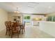 Bright dining area with an open floor plan, lovely chandelier, and sliding glass door to the backyard at 39721 Meadowood Loop, Zephyrhills, FL 33542