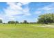 Scenic view of a well-maintained golf course with lush green grass, mature trees, and blue sky at 39721 Meadowood Loop, Zephyrhills, FL 33542