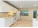 Kitchen featuring ample counter space, white cabinets, and a view to the backyard at 39721 Meadowood Loop, Zephyrhills, FL 33542