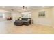 Open-concept living room featuring neutral tile flooring, an open layout, and a ceiling fan at 39721 Meadowood Loop, Zephyrhills, FL 33542