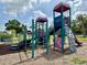 Community playground with climbing structure, slide and play area surrounded by wood chips at 39721 Meadowood Loop, Zephyrhills, FL 33542