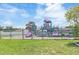 View of the fenced-in community playground area showcasing slides and climbing structures for children at 39721 Meadowood Loop, Zephyrhills, FL 33542