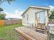 A wooden deck with white table and chairs overlooking a lush backyard with wood fence at 4339 58 N Ave, St Petersburg, FL 33714