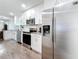 Contemporary kitchen with stainless steel appliances, white cabinetry, and hardwood flooring at 4339 58 N Ave, St Petersburg, FL 33714