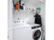 A laundry room with stacked washer and dryer, shelving, and ample storage space at 4339 58 N Ave, St Petersburg, FL 33714