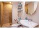 Cozy bathroom featuring a tiled shower, a circular mirror, and a sleek, white sink at 450 Knights Run Ave # 1003, Tampa, FL 33602