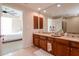 Spacious bathroom with double vanity, wood cabinets, and large mirror, complemented by tile flooring at 450 Knights Run Ave # 1003, Tampa, FL 33602