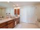 Well-lit bathroom featuring a double vanity with wood cabinets, a large mirror, and tile flooring at 450 Knights Run Ave # 1003, Tampa, FL 33602