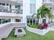 Relaxing courtyard featuring a fire pit, bench seating, landscaping, and manicured artificial turf at 450 Knights Run Ave # 1003, Tampa, FL 33602