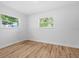 A minimalistic bedroom featuring two windows offering ample natural light and hardwood flooring at 454 35Th Ne Ave, St Petersburg, FL 33704