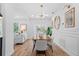 Elegant dining area with wood floors and modern lighting adjacent to the living room at 454 35Th Ne Ave, St Petersburg, FL 33704
