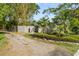 Charming driveway leads to the home, framed by vibrant tropical foliage and lush greenery at 454 35Th Ne Ave, St Petersburg, FL 33704