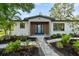Stylish home entry with a blue double door, stone pathway, and lush landscaping at 454 35Th Ne Ave, St Petersburg, FL 33704