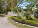 Landscaped yard with fence, decorative stone, and tropical plants at 454 35Th Ne Ave, St Petersburg, FL 33704