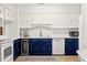 Bright kitchen featuring white subway tile, white and blue cabinets, and stainless steel appliances at 4616 S Matanzas Ave, Tampa, FL 33611