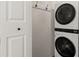 Modern white stacked washer and dryer inside, next to a white door with black hooks at 4616 S Matanzas Ave, Tampa, FL 33611