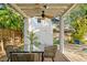 Outdoor patio features stylish dining set, ceiling fan, and view of the lush, private backyard and shed at 4616 S Matanzas Ave, Tampa, FL 33611