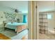 Bedroom with bathroom access featuring hardwood floors, fan, and neutral accents at 4725 Soapstone Dr, Tampa, FL 33615