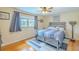 Cozy bedroom featuring a ceiling fan, hardwood floors, a window with curtains, and a stylish gray bed frame at 4725 Soapstone Dr, Tampa, FL 33615